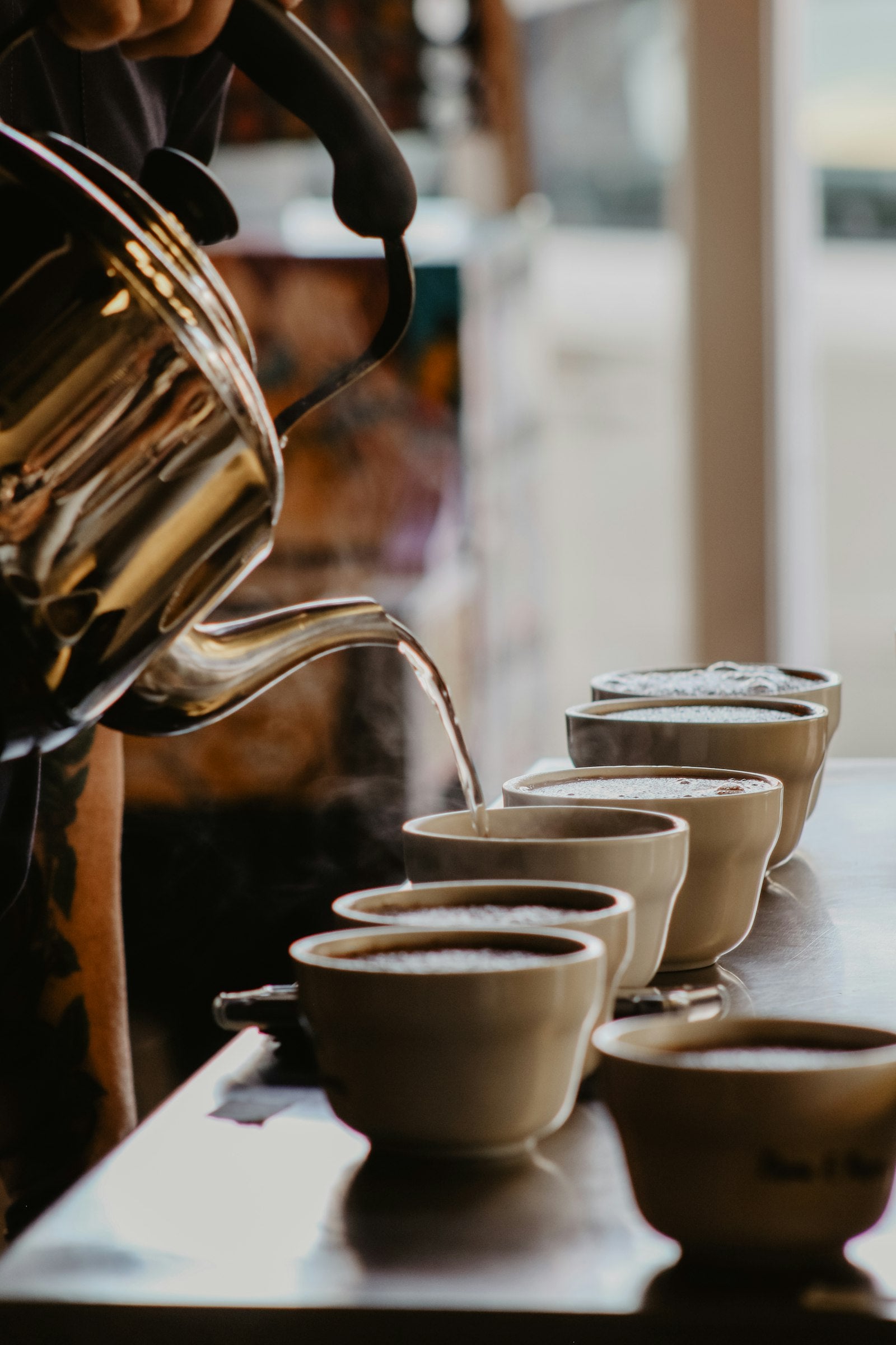 Rót nước nóng vào dãy bát thử nếm cupping để đánh giá cà phê đặc sản